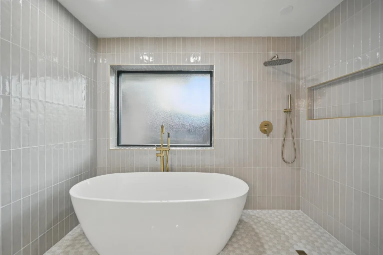 Dallas TX primary bathroom remodel with freestanding tub and frosted window