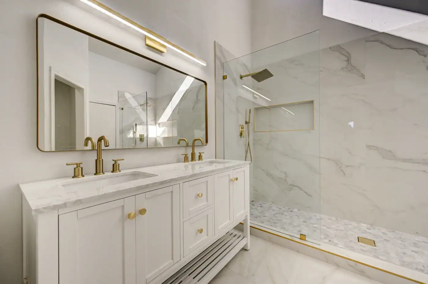 Bathroom remodeling in Farmers Branch. New master bathroom with vanity, countertop, his and her sinks, walk-in shower, and gold fixtures