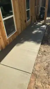 Fresh concrete walkway and patio poured along ADU exterior