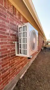 High-efficiency mini-split HVAC condenser installed on a brick attached ADU