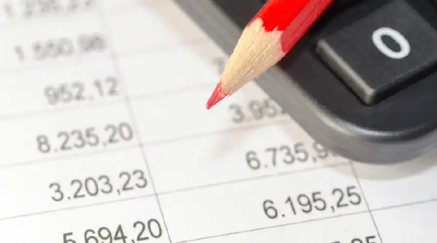 Close-up of a red pencil and calculator showing budget planning for bathroom remodeling in Dallas-Fort Worth TX.