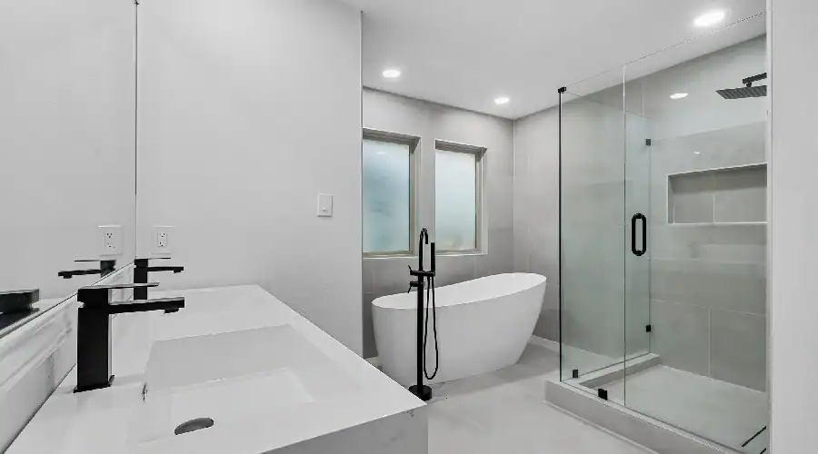 Modern bathroom with freestanding tub and glass shower in Bedford, TX, by Home Build and Designs.