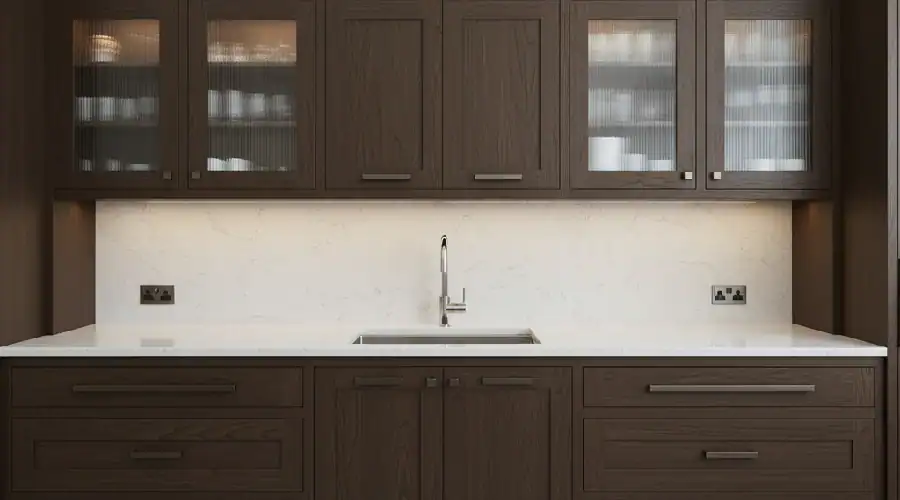Dark wood custom cabinets with glass uppers, deep drawers, and a quartz countertop in a DFW kitchen.