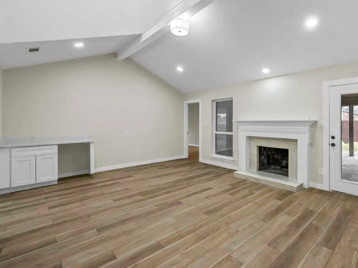 After—DFW living room remodel with wood-look tile flooring, white fireplace mantel, recessed lighting, and built-in bar