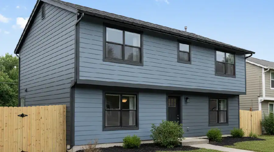 DFW two-story home after fiber cement lap siding upgrade in slate blue with black trim and refreshed windows