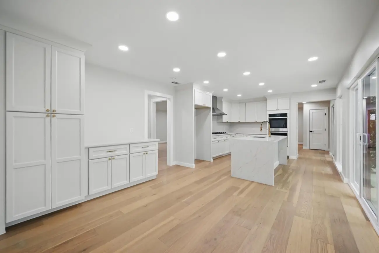 Whole-home renovation — open kitchen & living with a waterfall island · Dallas