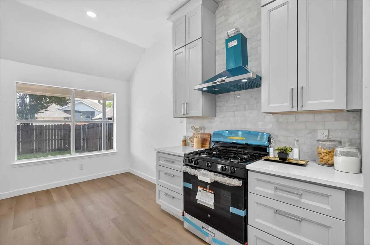 Finished Kitchen With Gray Cabinets Black Range And Blue 011